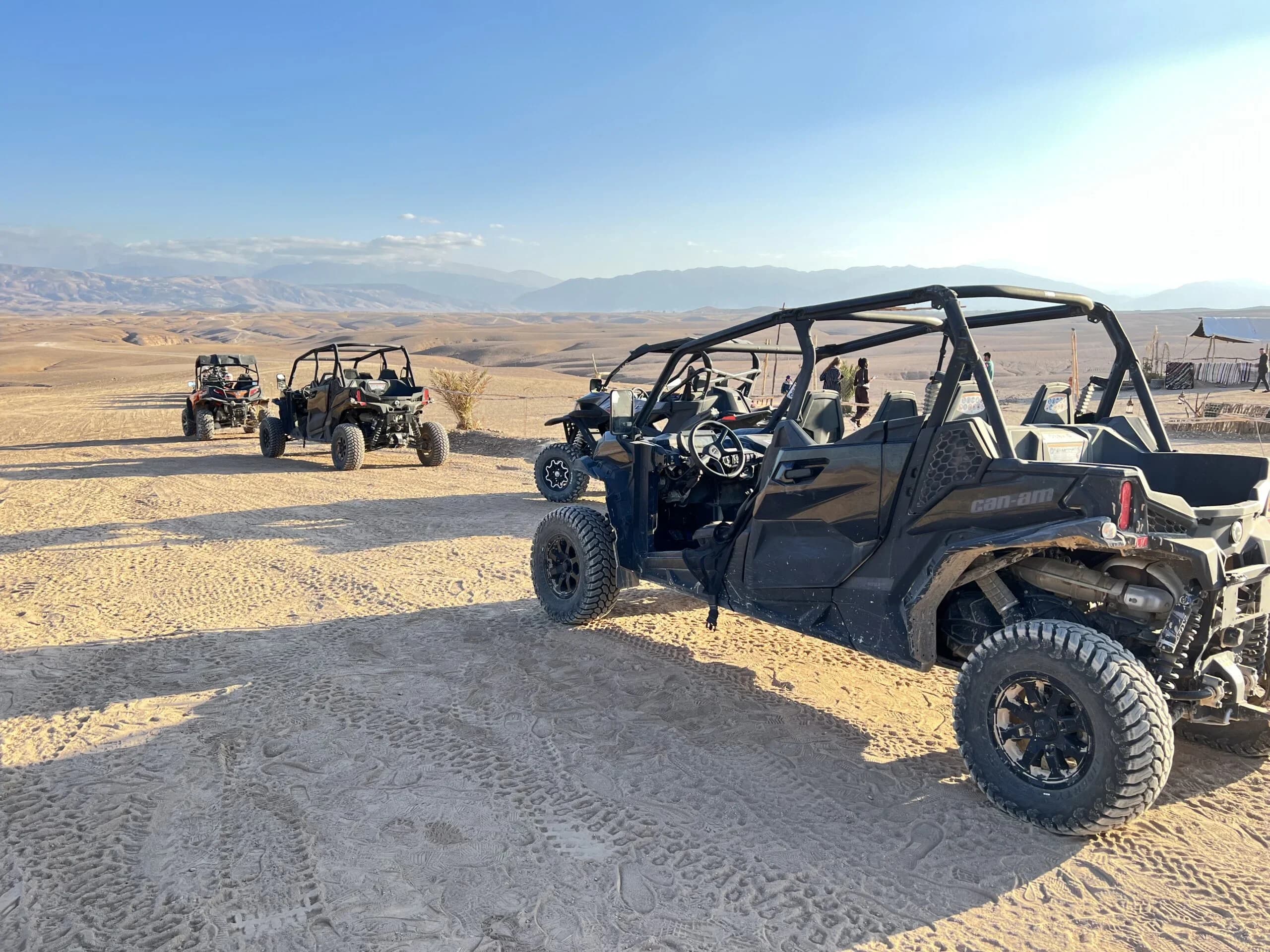 A convoy of off-road buggies parked at a desert camp in Agafay